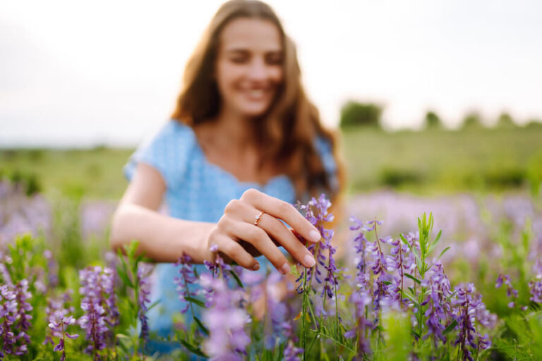 Kobieta chwytająca roślinę lawendy na polu