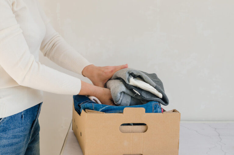 Kobieta wkładająca odzież do kartonu