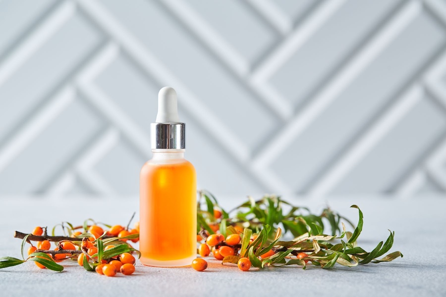 Olejek z rokitnika, obok świeże owoce