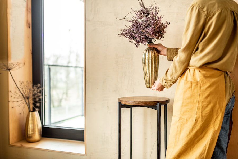 Kobieta kładąca wazon z lawendą na stolik