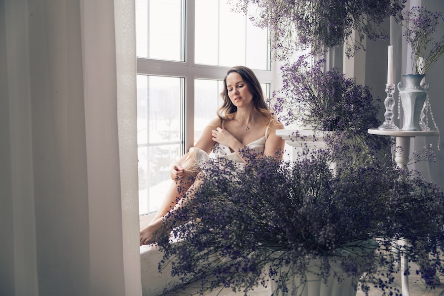 Kobieta siedząca na parapecie przy lawendzie