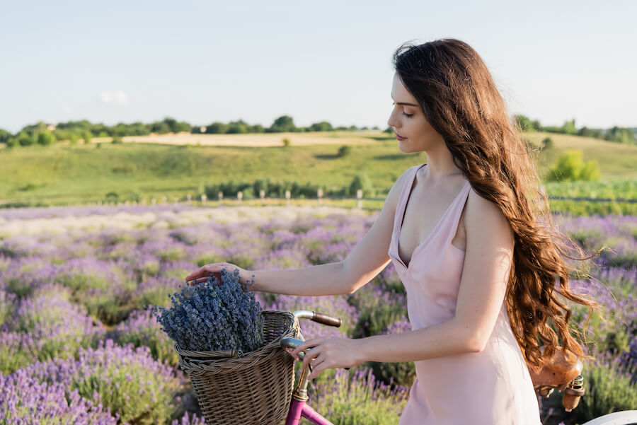 Kobieta z rowerem i lawendą w koszyku