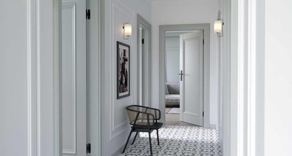 Biały korytarz z uchylonymi drzwiami do pomieszczeļ
