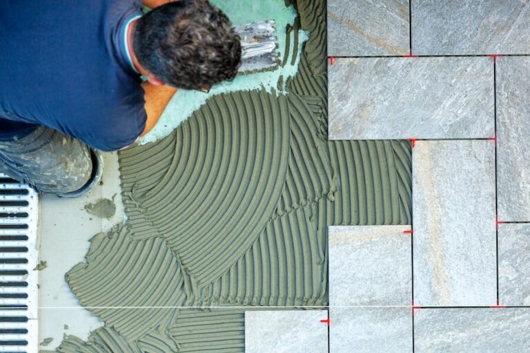 Mężczyzna rozprowadzający klej dla płytek